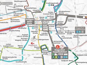Ausschnitt des kartografischen KMG-Liniennetzes zeigt die Knotenpunkte Klagenfurt Hauptbahnhof und Heiligengeistplatz. Man sieht hier die verschiedenfärbigen Linien mit den jeweiligen Haltestellen, die von diesen Knotenpunkten aus in alle Himmeslrichtungen fahren.