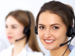 Kundenservice-Mitarbeiterin mit Headset lächelt in die Kamera