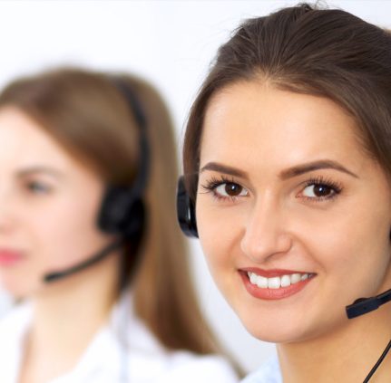 Kundenservice-Mitarbeiterin mit Headset lächelt in die Kamera